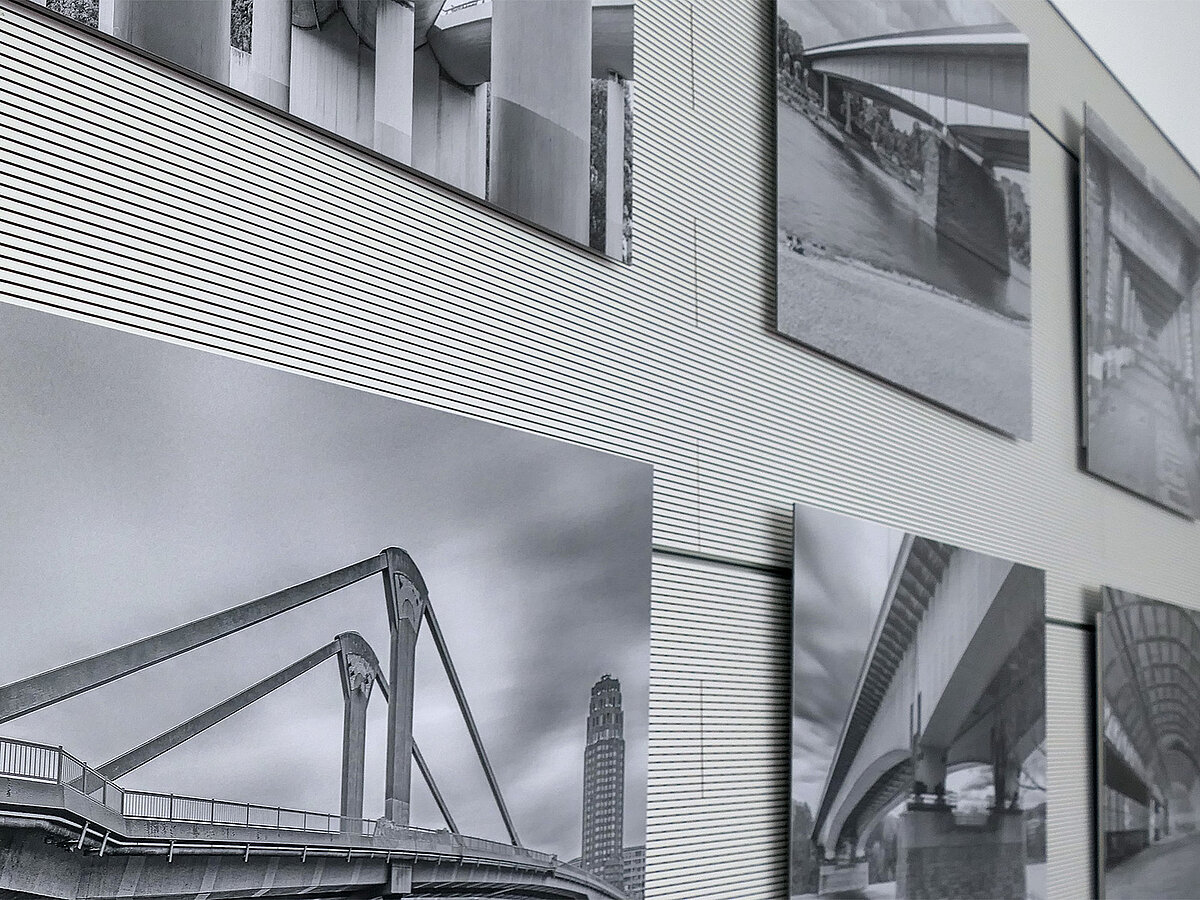 Eine Wand mit schwarz-weiß Fotografien, seitlich abfotografiert.