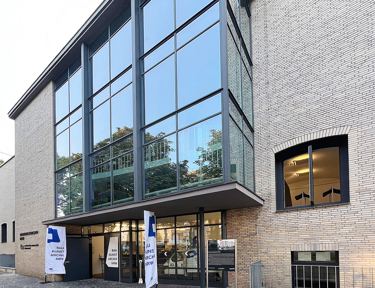 Ein Gebäude im Anschnitt mit heller Fassade, teilweise mit Glaselementen.