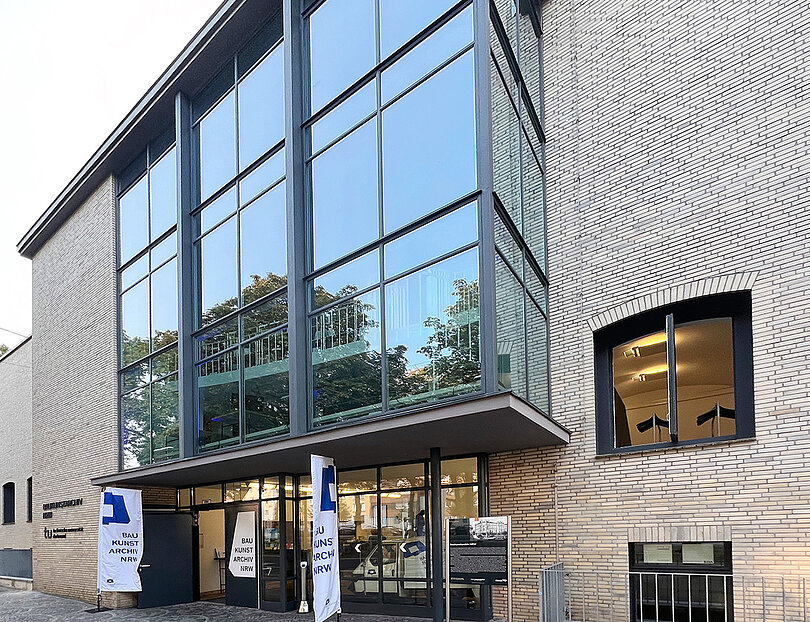 Ein Gebäude im Anschnitt mit heller Fassade, teilweise mit Glaselementen.