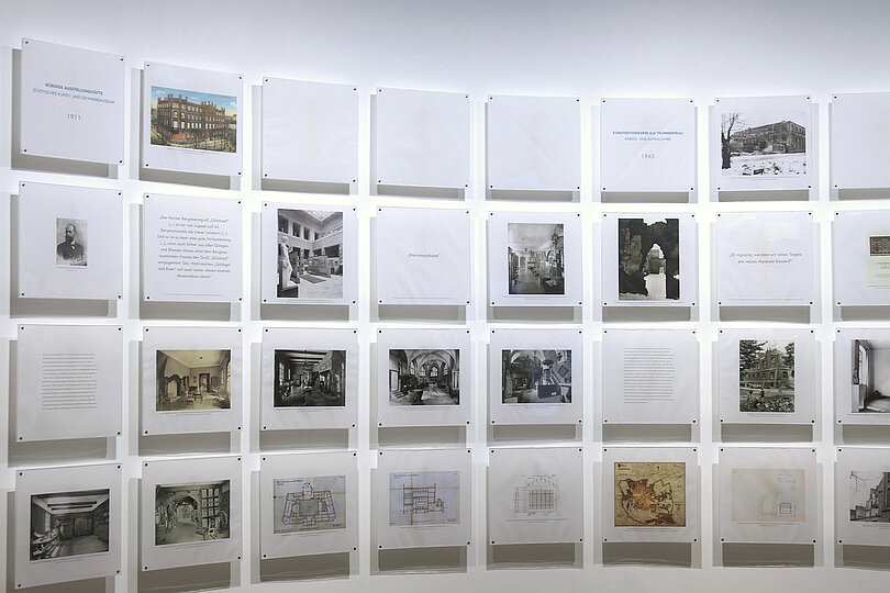 Ausstellung mit Bild- und Texttafeln an einer Wand.