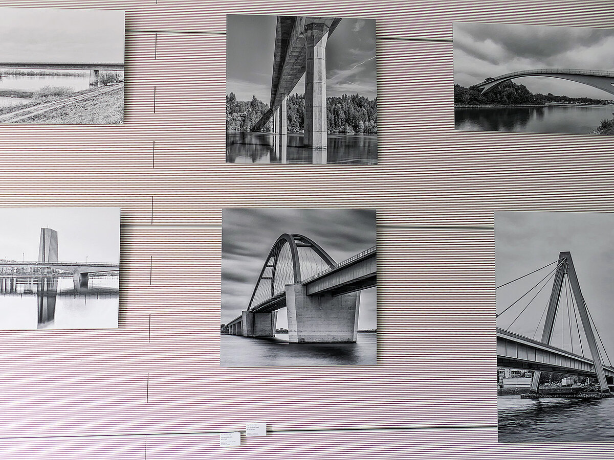 Eine Wand mit schwarz-weiß Fotografien.