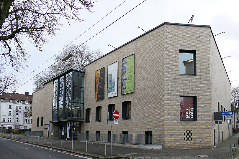 Ein Gebäude mit heller Fassade, teilweise mit Glaselementen.
