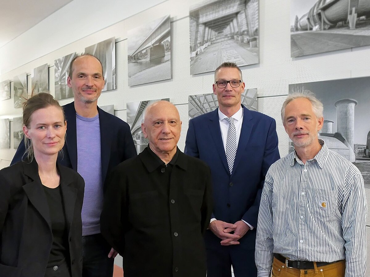 Eine Gruppe Personen steht beisammen und lächelt in die Kamera.