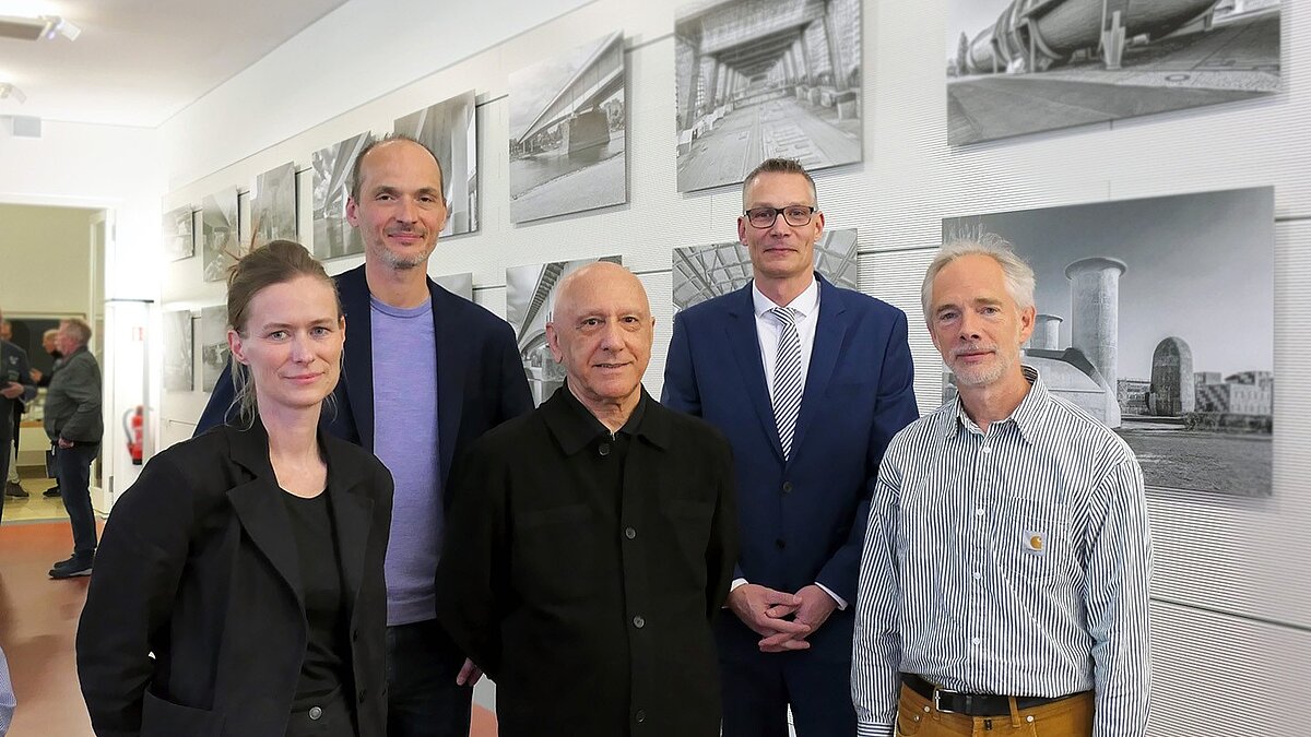 Eine Gruppe Personen steht beisammen und lächelt in die Kamera.