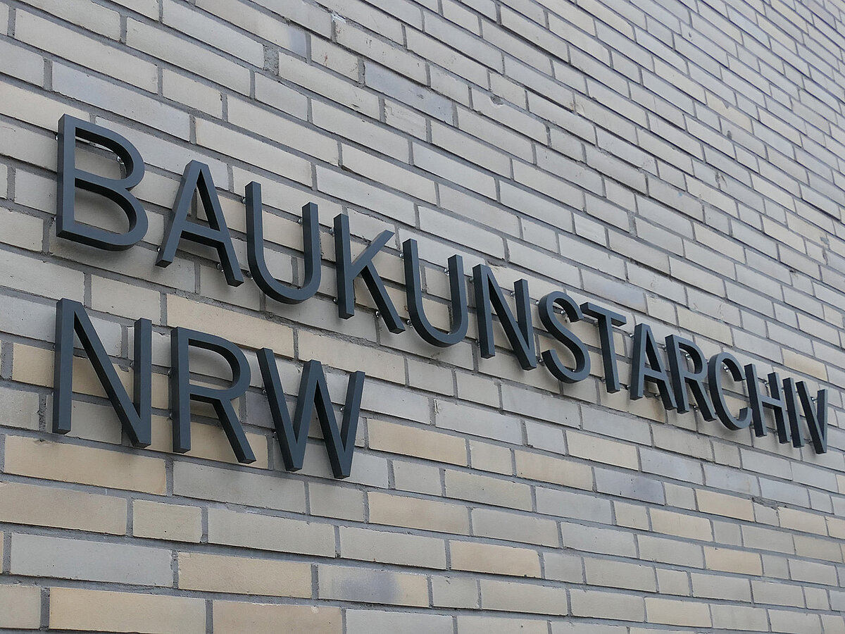 Blick auf eine helle Gebäudefassade mit der Aufschrift "Baukunstarchiv NRW".