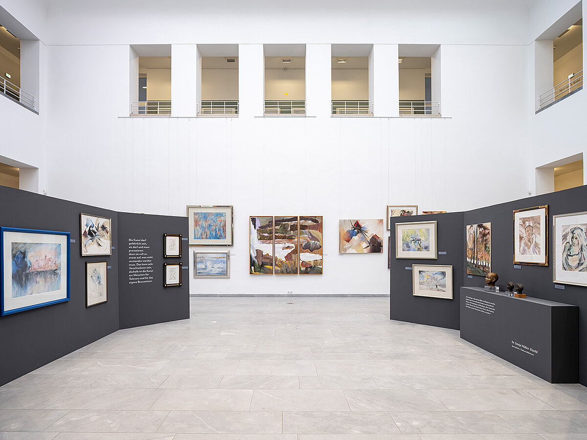 Heller Ausstellungsraum mit einer Bilderausstellung