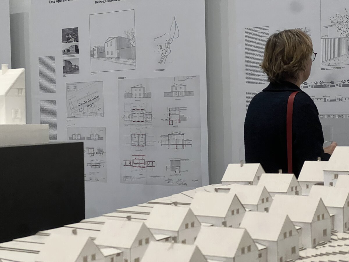Eine Person in einem Ausstellungsraum. Die Person betrachtet Texttafeln.